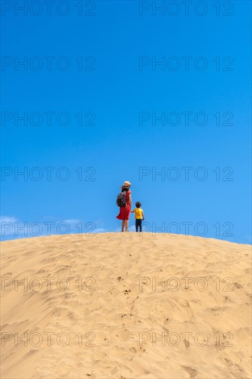 Mother and child smiling in the dunes of Maspalomas in summer, Gran Canaria, Canary Islands