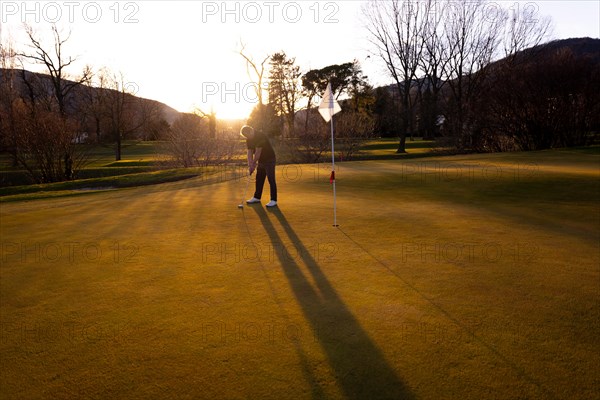 Male Golfer Concentration on the Putting Green on Golf Course in Sunset with Shadow in Switzerland. | MR:yes Mats-CH-02-05-2023