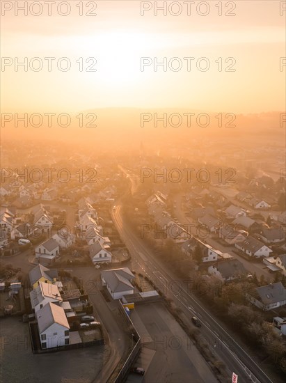 Sunrise over a street with houses and foggy background in winter, Gechingen, Black Forest, Germany, Europe