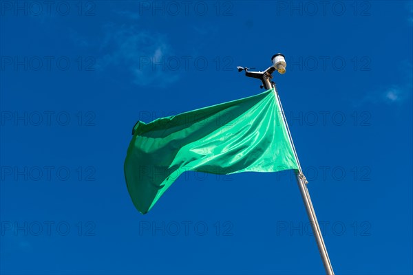 Green flag on the beach in summer summer, lifeguards sign that you can swim