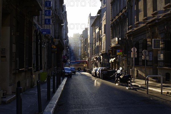 Marseille in the morning, city street with sunlit and shaded areas and parked cars, Marseille, Departement Bouches-du-Rhone, Region Provence-Alpes-Cote d'Azur, France, Europe
