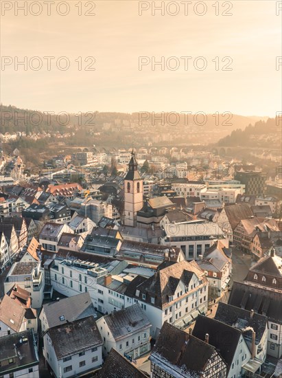 Warmly lit town with view of church and interlaced roofs, sunrise, Nagold, Black Forest, Germany, Europe