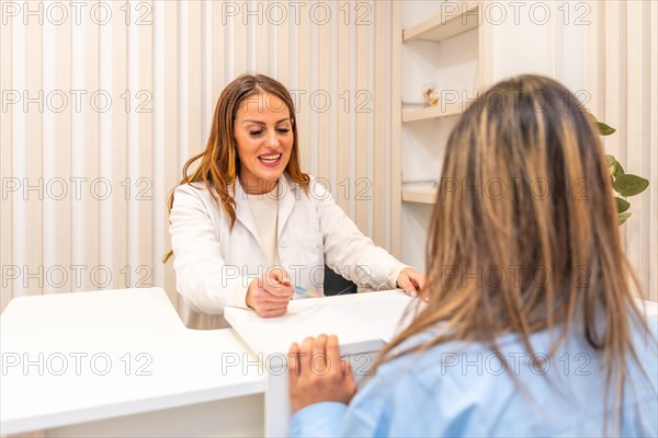 Aesthetic doctor attending a female client in the reception of the beautician surgery clinic