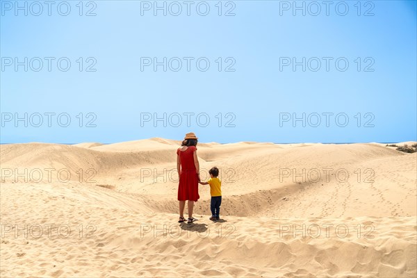 Mother and son on vacation very happy in the dunes of Maspalomas, Gran Canaria, Canary Islands