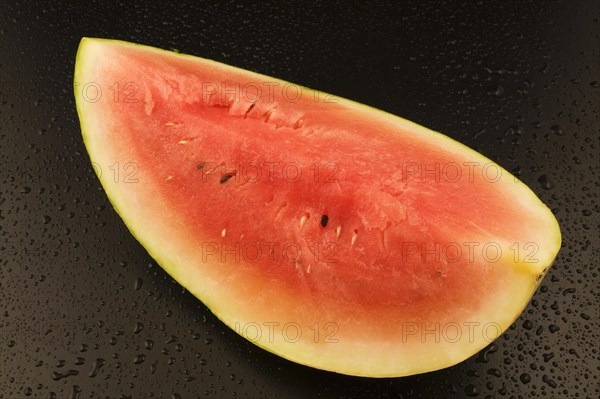 Top view and close-up of half a Citrullus lanatus, Watermelon on black background with water droplets, Studio Composition, Quebec, Canada, North America