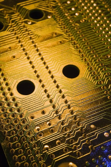 Close-up of golden and green lighted electronic computer circuit board with silver solder points and lines, Studio Composition, Quebec, Canada, North America