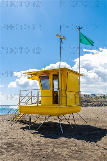 Yellow lifeguard tower in California with green flag