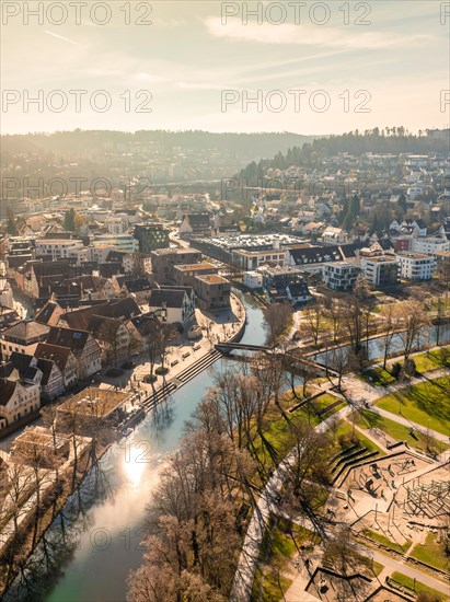 Aerial view of a city panorama with river and sun reflections next to urban architecture, sunrise, Nagold, Black Forest, Germany, Europe