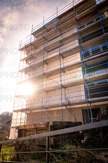 Scaffolding in front of a new building with a half-timbered house in the background, Calw, Black Forest, Germany, Europe