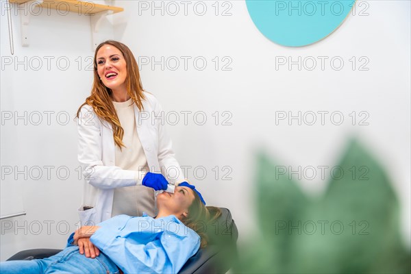 Happy doctor during a beautician treatment in the clinic with a patient