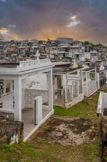 Famous cemetery, many mausoleums or large tombs decorated with tiles, often in black and white. Densely built buildings under a sunset Cimetiere de Morne-a-l'eau, Grand Terre, Guadeloupe, Caribbean, North America