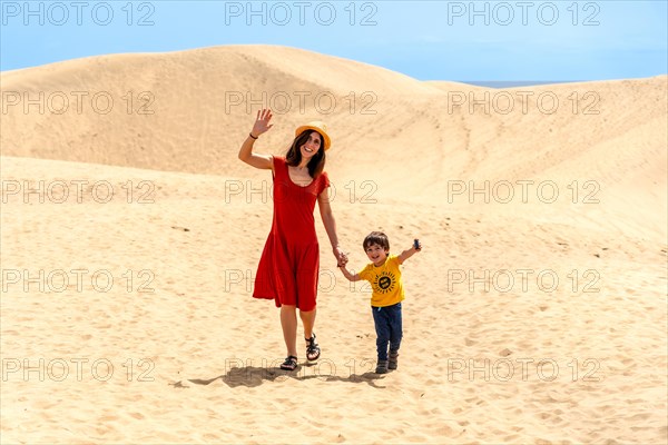 Mother and son tourists enjoying in the dunes of Maspalomas, Gran Canaria, Canary Islands