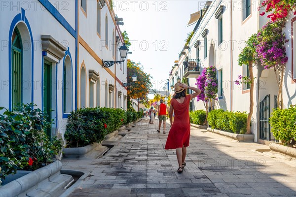 A woman walking in the port of the coastal town Mogan in the south of Gran Canaria. Spain