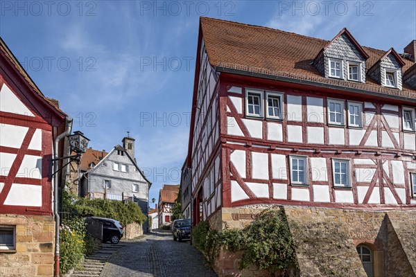 Old half-timbered houses on a narrow steep lane, Steingasse, old town, Ortenberg, Vogelsberg, Wetterau, Hesse, Germany, Europe