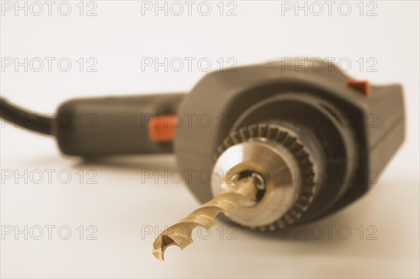 Close-up of electric drill with black power cord and titanium bit on white background, Studio Composition, Quebec, Canada, North America