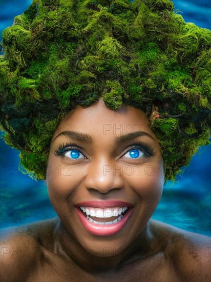 A woman with a vibrant smile and green moss hair submerged in blue water, earth day concept, AI generated