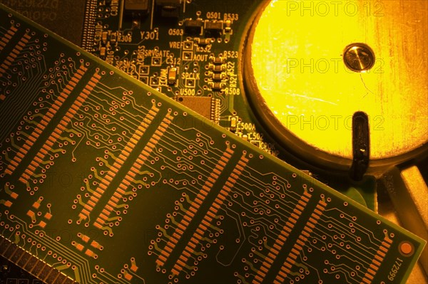 Close-up of orange and yellow lighted electronic computer circuit boards with hard drive, Studio Composition, Quebec, Canada, North America