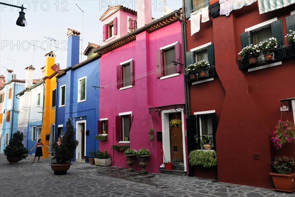 Colourful houses, Burano, Burano Island, Colourful architecture and blooming flower pots along a quiet cobbled street, Burano, Venice, Veneto, Italy, Europe