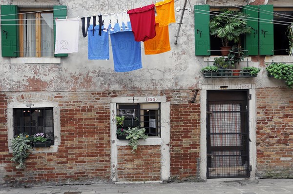 Colourful laundry hanging on a washing line in front of old Venetian house facades, Venice, Veneto, Italy, Europe