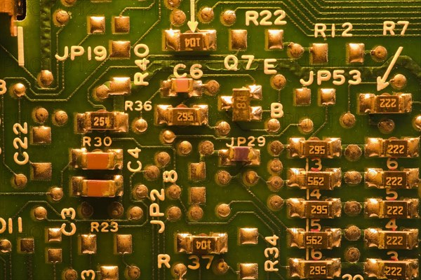 Close-up of golden yellow lighted green electronic computer circuit board with lines and silver solder points, Studio Composition, Quebec, Canada, North America