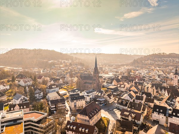 Sunny town view with church and traditional houses surrounded by river, hills and trees, sunrise, Nagold, Black Forest, Germany, Europe