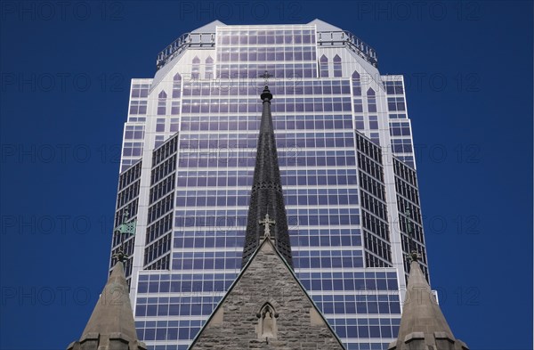 Old Christ Church Cathedral facade with spire and modern architectural steel and blue tinted glass windows KPMG office tower in summer, Montreal, Quebec, Canada, North America