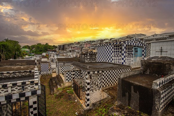 Famous cemetery, many mausoleums or large tombs decorated with tiles, often in black and white. Densely built buildings under a sunset Cimetiere de Morne-a-l'eau, Grand Terre, Guadeloupe, Caribbean, North America