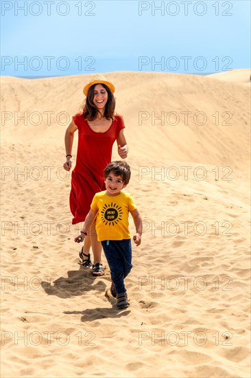 Mother and son tourists on vacation very happy in the dunes of Maspalomas, Gran Canaria, Canary Islands