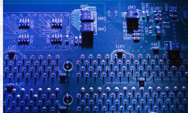 Close-up of blue lighted electronic computer circuit board with microchips and silver solder points, Studio Composition, Quebec, Canada, North America