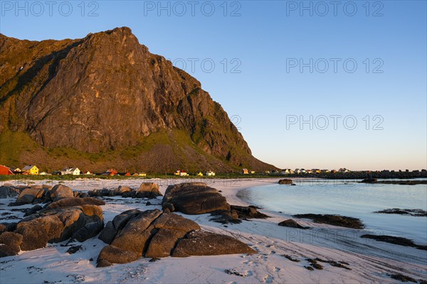 Landscape on the Lofoten Islands. The small village of Eggum, sandy beach, rocks, sea and mountain in the midnight sun. Golden hour, at night. Good weather, blue sky. Early summer. Eggum, Vestvagoya, Lofoten, Norway, Europe