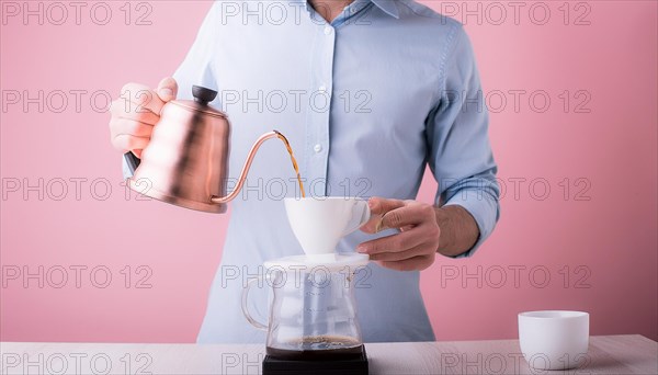 Man in blue shirt using a stainless steel kettle to brew coffee on a pink background, horizontal, AI generated