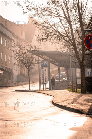 A foggy street in the morning light with a parking sign in the foreground, sunrise, Nagold, Black Forest, Germany, Europe