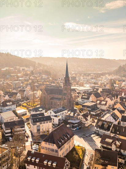 Cityscape with a view of a church tower and residential buildings in atmospheric autumn light, sunrise, Nagold, Black Forest, Germany, Europe