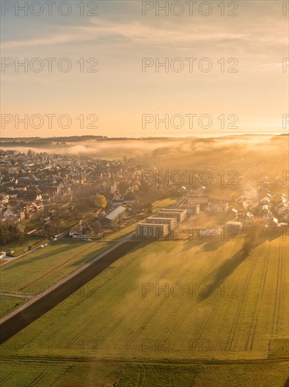 The morning sun gently illuminates the foggy landscape around the town, Gechingen, Black Forest, Germany, Europe