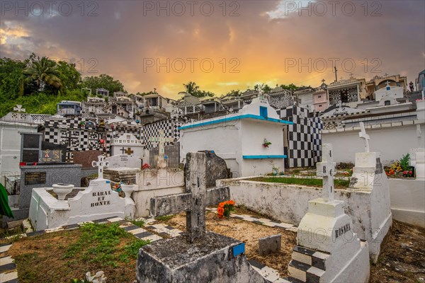 Famous cemetery, many mausoleums or large tombs decorated with tiles, often in black and white. Densely built buildings under a sunset Cimetiere de Morne-a-l'eau, Grand Terre, Guadeloupe, Caribbean, North America