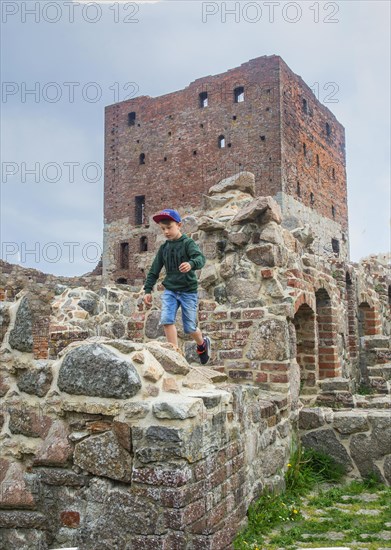 Boy run on Hammershus which was Scandinavia's largest medieval fortification and is one of the largest medieval fortifications in Northern Europe. Now ruin and located on the island Bornholm, Denmark, Baltic Sea, Scandinavia, Europe