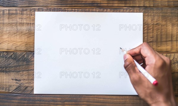 A hand holding a graphite pencil poised over a blank sheet of white paper AI generated