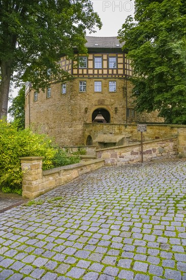 Access to the moated castle Sachsenheim, Grosssachsenheim Castle, former moated castle, archway, cobblestones, path, wall, bridge, crossing, coat of arms, with inscription, exterior lights, lamps, architecture, historic building from the 15th century, Sachsenheim, Ludwigsburg district, Baden-Wuerttemberg, Germany, Europe