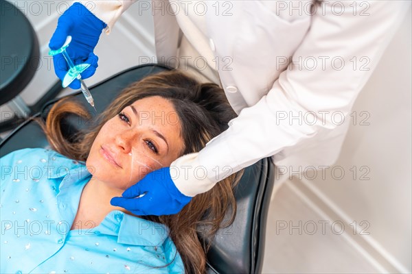 Woman receiving an hyaluronic acid injection to the face in a beauty clinic