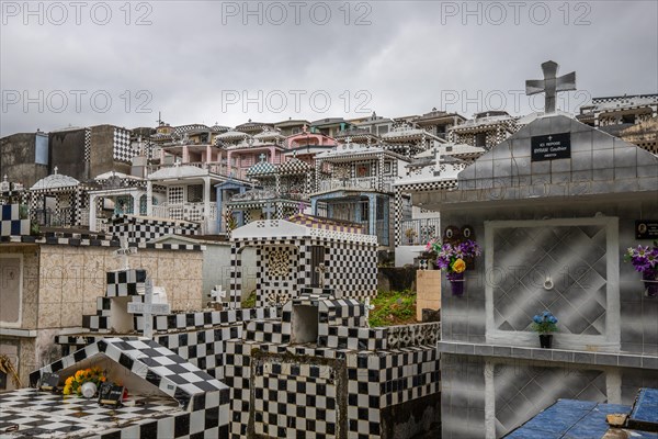 Famous cemetery, many mausoleums or large tombs decorated with tiles, often in black and white. Densely built buildings under a dramatic cloud cover Cimetiere de Morne-a-l'eau, Grand Terre, Guadeloupe, Caribbean, North America