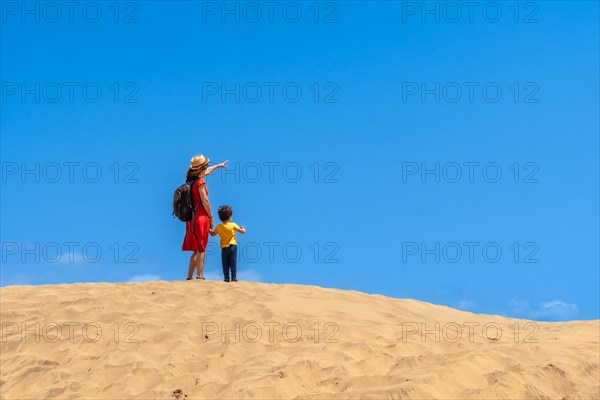 Mother and child smiling in the dunes of Maspalomas in summer, Gran Canaria, Canary Islands