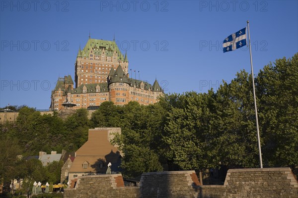 Historic Chateau Frontenac fairmont hotel building and old fortification wall with Quebec Fleur de Lys provincial flag billowing in the wind, Quebec City, Quebec, Canada, North America