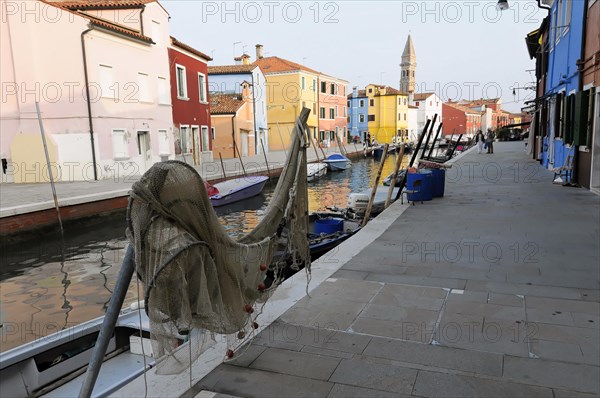 Colourful houses, Burano, Burano Island, A fishing boat with a net in the foreground against a backdrop of colourful houses on the canal, Burano, Venice, Veneto, Italy, Europe