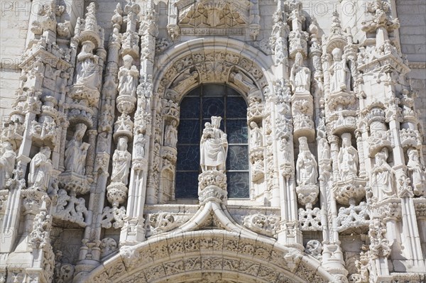 Arched window with decorated carved sculptures on facade of Jeronimos Monastery, Lisbon, Portugal, Europe