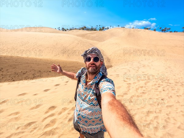 Selfie of a tourist with sunglasses and turban enjoying in the dunes of Maspalomas, Gran Canaria, Canary Islands