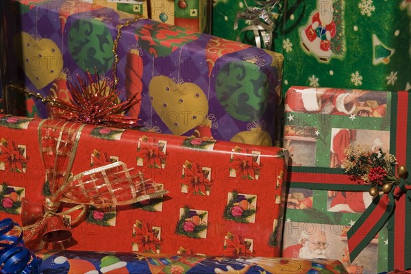 Close-up of boxed Christmas gifts wrapped with colorful red, green, purple and gold wrapping paper, Studio Composition, Quebec, Canada, North America