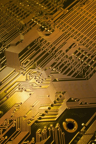 Close-up of golden yellow lighted electronic computer circuit board with lines and silver solder points, Studio Composition, Quebec, Canada, North America