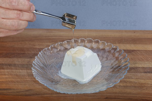 South German cuisine, preparation of oven vegetables, goat's cheese, drizzle cream cheese with honey, honey lifter, healthy cooking, vegetarian, food, studio, man's hand, glass plate, Germany, Europe