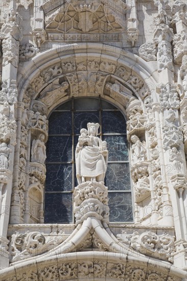 Arched window decorated with carved sculptures on facade of Jeronimos Monastery, Lisbon, Portugal, Europe
