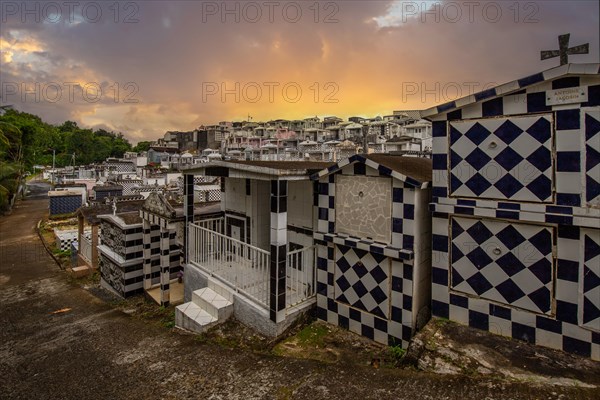 Famous cemetery, many mausoleums or large tombs decorated with tiles, often in black and white. Densely built buildings under a sunset Cimetiere de Morne-a-l'eau, Grand Terre, Guadeloupe, Caribbean, North America